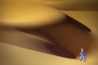 Solitary man walking through sahara desert