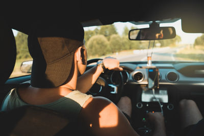 Side view of man photographing in car