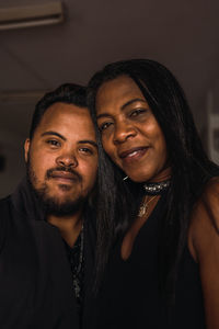 Delighted african american female and male in black clothes standing together and looking at camera