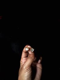 Cropped image of hands holding diamond rings at night