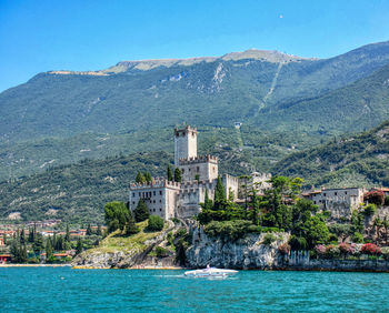Buildings in a sea with mountain range in the background