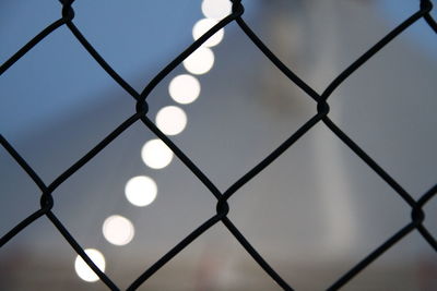 Low angle view of chainlink fence against sky