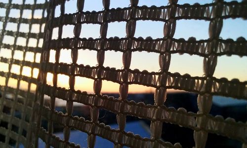 Close-up of rusty metal against sky during sunset