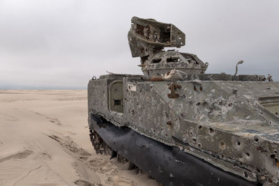 Army tank with bullet holes in the sand