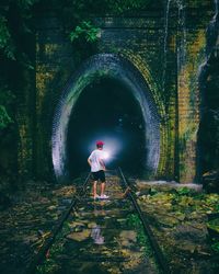 Rear view of man standing in tunnel