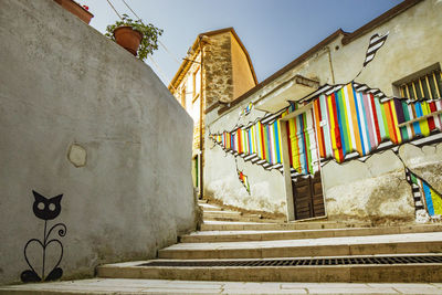 Low angle view of staircase amidst buildings against sky