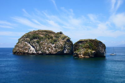 Rock formation in sea against sky