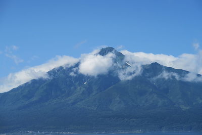 Scenic view of snowcapped mountains against blue sky