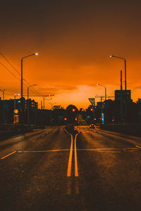 Vehicles on road at sunset