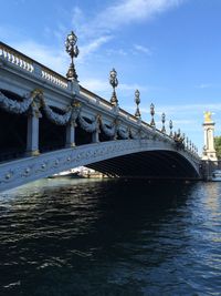 View of bridge over water against cloudy sky