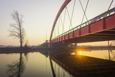 Bridge over river during sunset