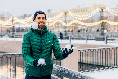 Portrait of smiling man standing in snow