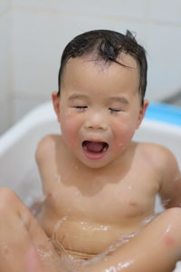 Close-up portrait of boy taking a bath