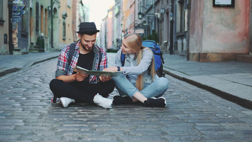 Young couple sitting on street in city