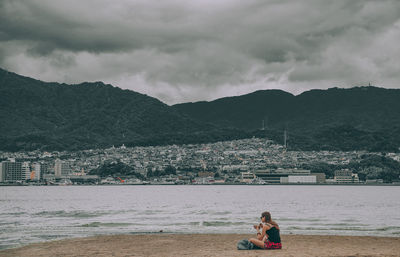 Woman sitting by lake