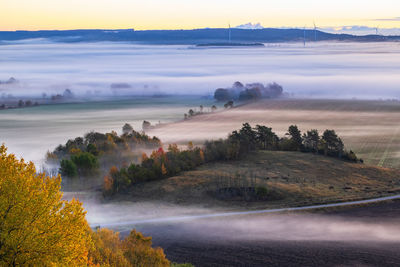 Scenic view of landscape against sky during foggy weather