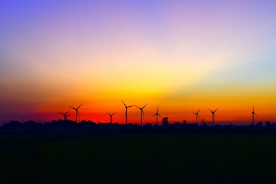 Silhouette of wind turbines at sunset