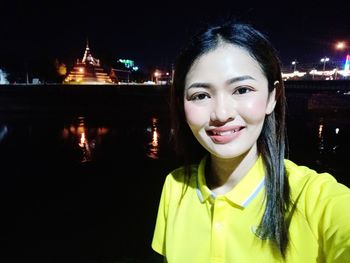 Portrait of smiling young woman at night