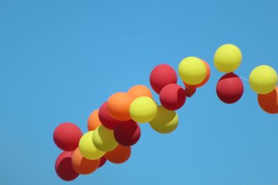 Low angle view of balloons against blue sky