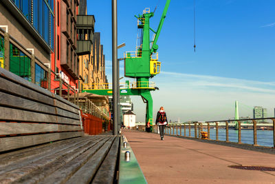 Man on pier by city against sky