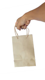 Midsection of woman holding paper against white background