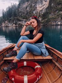 Young woman sitting on boat on lake