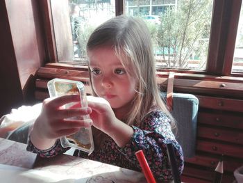 Cute girl holding toy on table