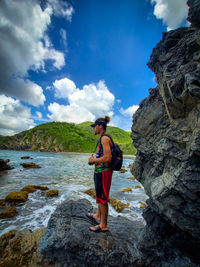 Full length of man standing on rock against sea