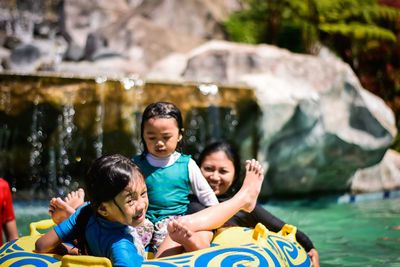 Girls with mother in inflatable ring at water park