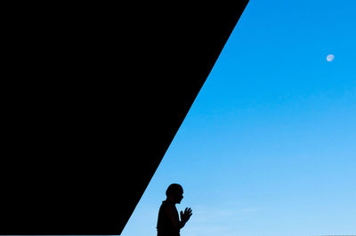 Close-up of man against blue sky