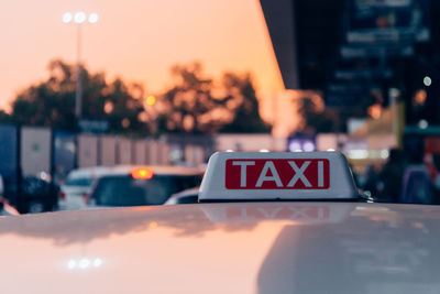 Close-up of taxi text on car roof during sunset