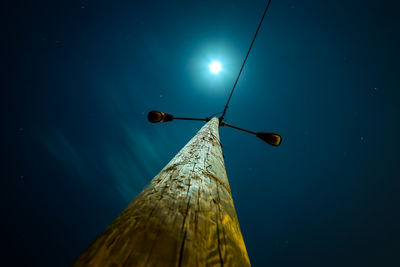 Low angle view of illuminated street light against blue sky