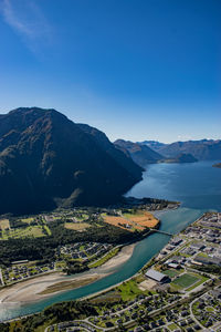 High angle view of townscape by mountains against clear blue sky