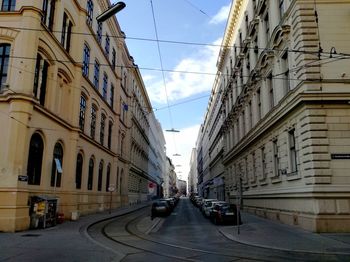 Cars on street in city against sky