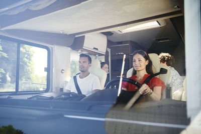 Family sitting in motor home seen from windshield