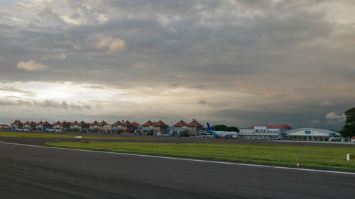 Houses on field by buildings against sky