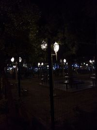 Illuminated street light against sky at night