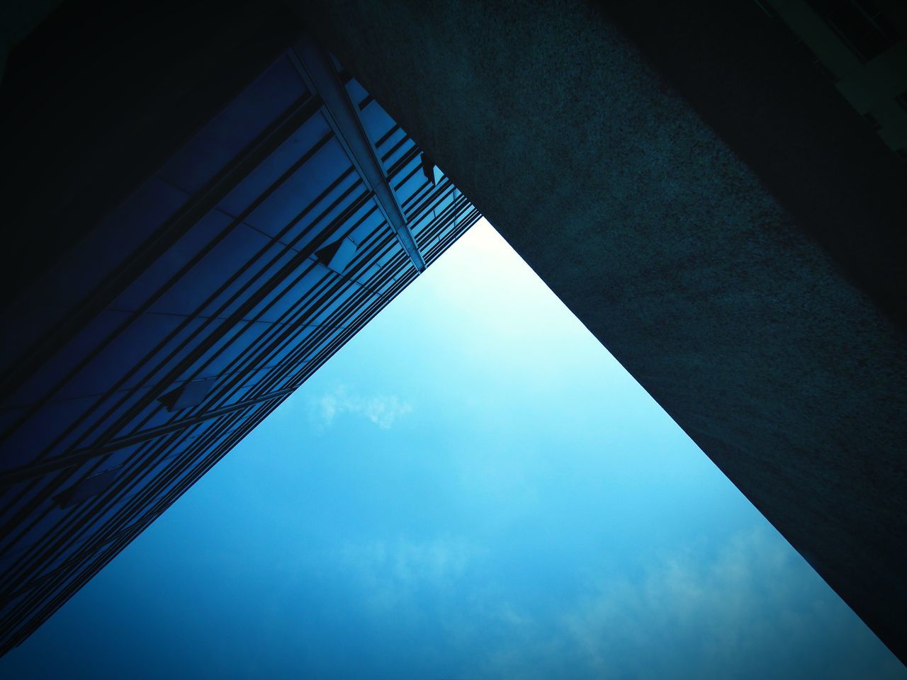low angle view, architecture, built structure, sky, building exterior, reflection, modern, glass - material, cloud - sky, directly below, building, blue, office building, window, no people, tall - high, cloud, day, city, outdoors