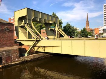 Bridge over river against buildings in city