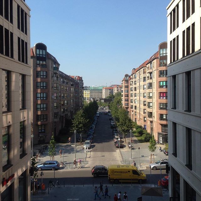 building exterior, architecture, built structure, clear sky, city, transportation, building, residential building, residential structure, street, car, mode of transport, copy space, incidental people, land vehicle, road, the way forward, city life, day, diminishing perspective