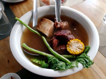 High angle shot of bowl with soup on table