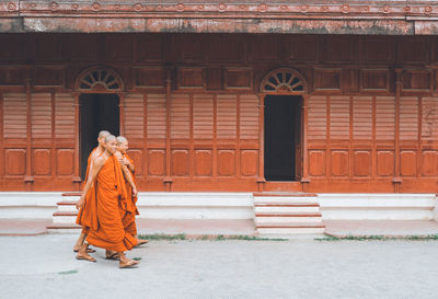 Rear view of woman walking against building