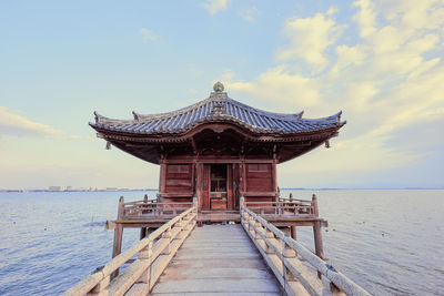 Built structure on pier over sea against sky