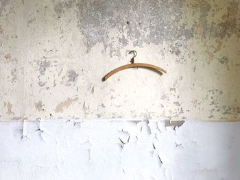 Old wall, stripped of wallpaper and paint, with a coat hanger 