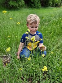 Little boy in a field picking wildflowers