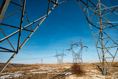 Low angle view of electricity pylon against sky