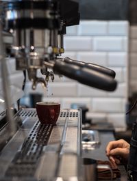 Close-up of coffee pouring in cup at cafe