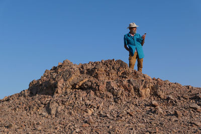 Senior man using mobile phone in the desert 