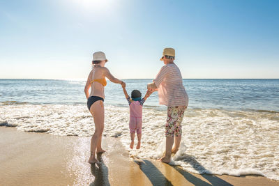 People enjoying at beach against sky