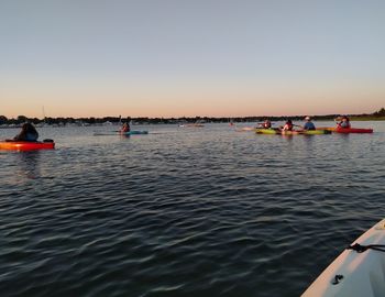 People on sea against clear sky